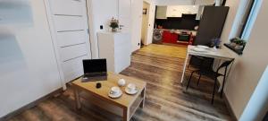 a small living room with a laptop on a table at Quiet Apartment in Oświęcim +4 photos