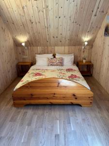 a bed in a room with a wooden ceiling at Namelis Bitidė, sodyba Latkrantė, Druskininkai in Latežeris