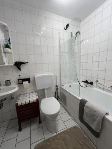 a bathroom with a toilet and a tub and a sink at Domblick Apartment in Aachen +32 photos