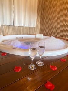 two glasses of water sitting on a table in a bath tub at Estalagem Andorinhas in Monte Verde +80 photos