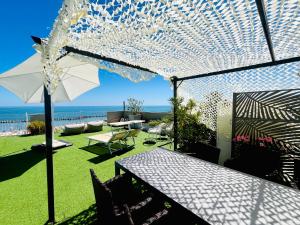a patio with a table and an umbrella at Residence Frontemare in Rimini +70 photos
