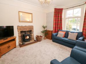 a living room with a blue couch and a fireplace at Dorset Villas in Matlock