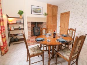 a dining room with a table and chairs and a fireplace at Dorset Villas in Matlock