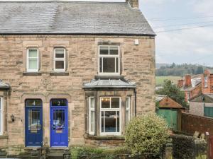 an old stone house with blue doors at Dorset Villas in Matlock