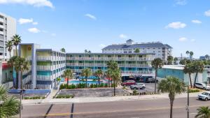 a large building with a parking lot and palm trees at Clearwater Beach Pelican 2 in Clearwater Beach