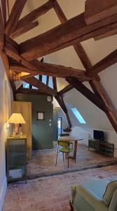 a living room with wooden ceilings and a table at Logis La Vachère in Avallon