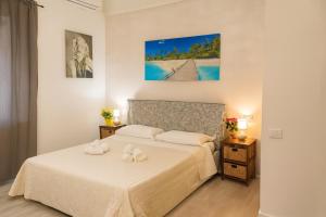 a bedroom with a bed with two white towels on it at Hotel Ariston in Piombino