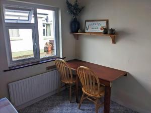 a dining room table with two chairs and a window at Dunloe View in Killarney