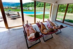 three girls laying in hammocks in a room with a pool at Camping Bella Austria - Maeva Vacansoleil in Sankt Peter am Kammersberg