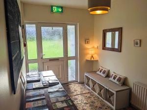 a room with a door and a bench with books at Dunloe View in Killarney