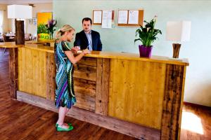 a woman standing in front of a counter with a man at Camping Bella Austria - Maeva Vacansoleil in Sankt Peter am Kammersberg