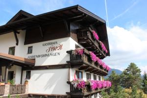 ein Gebäude mit Blumen auf den Balkonen in der Unterkunft Gästehaus Friedl in Imst