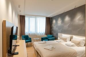 a hotel room with two beds and blue chairs at CENTRAL Stars Apartments & Free parking in Vrnjačka Banja +274 photos
