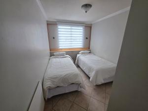 two beds in a small room with a window at Maitencillo Habitamar in Maitencillo +33 photos