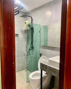 a bathroom with a shower and a toilet and a sink at Zhejiang Pakxe Hotel in Pakse