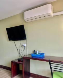 a room with a television and a desk with a deskablishthritisthritisthritisthritis at Zhejiang Pakxe Hotel in Pakse