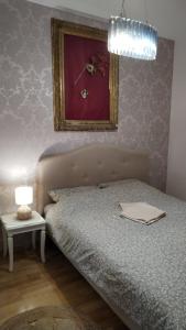 a bedroom with a bed and a picture on the wall at Cozy in Petrovaradin