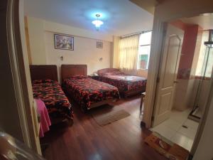 a small room with two beds and a door at Hotel Savoy in La Paz