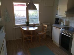 een keuken met een tafel en twee stoelen en een tafel bij Lingonberry Cottage in Tammisaari