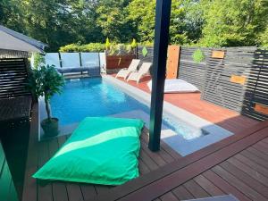 a swimming pool with a green pillow on a deck at La Suite Diamant in Theux