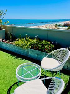 two chairs and a table on a balcony overlooking the beach at Residence Frontemare in Rimini