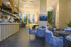 a restaurant with tables and chairs and a bar at Martiness Hotel Durres in Durrës