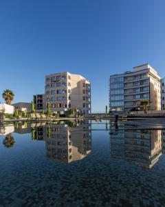 two tall buildings are reflected in a body of water at BOUMERDES PLAZA Hôtel & Spa in Boumerdes