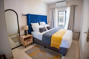 a bedroom with a large bed and a window at Lerako Apartment in Gaborone +25 photos