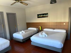 a hotel room with two beds with white sheets at Hostal La Estación in Ávila