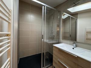 a bathroom with a sink and a glass shower at Cocon Mansardé - Velux et Clim - Hyper Centre in Toulouse