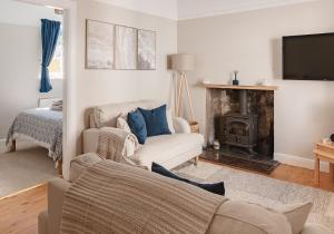 a living room with a couch and a fireplace at Doug's Cottage in Elie