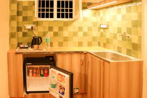a kitchen with a sink and a small refrigerator at Le Sara's Nest in Pondicherry