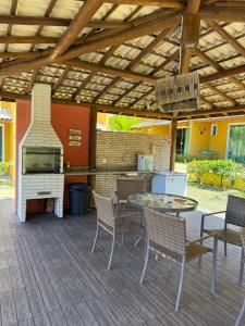 a patio with a table and chairs and a grill at Casa summer flats 23 Imbassai in Imbassai