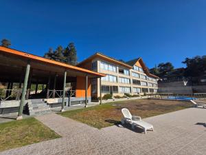 a white chair sitting in front of a building at Departamento Lago Vichuquen in Vichuquén Lake