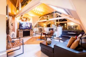 a living room with a couch and a dining room at La Suite Diamant in Theux