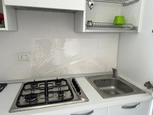 a kitchen counter with a sink and a stove at Appartamentino Bianco in Rio Marina
