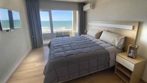 a bedroom with a bed with a view of the ocean at Oceano in Necochea +27 photos