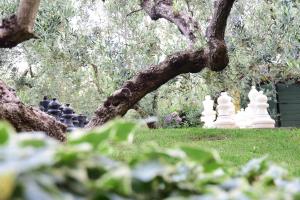 a tree with white statues in a park at La Meridiana in Lanuvio