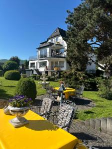a yellow table and chairs in front of a house at Haus Marientaler Au GbR in Zell an der Mosel