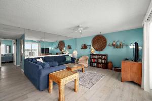 a living room with a blue couch and a table at Crab Cove 302 in Ocean City