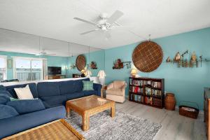 a living room with a blue couch and a table at Crab Cove 302 in Ocean City