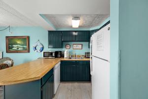 a kitchen with green cabinets and a white refrigerator at Crab Cove 302 in Ocean City +32 photos