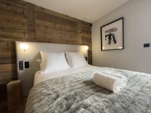 a bedroom with a large bed with a wooden wall at Chalet Suzane - Panorama Mont-Blanc & jacuzzi in Combloux +46 photos