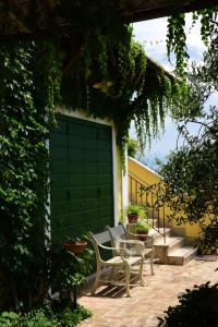 two chairs sitting next to a green garage door at La Meridiana in Lanuvio +97 photos