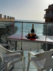 a table with a bottle of wine and two chairs at Apartamentos Marjal 3 in Guardamar del Segura