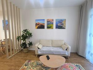 a living room with a couch and paintings on the wall at Zolu apartment in Ulaanbaatar