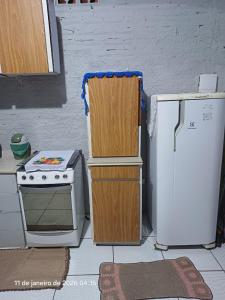 a kitchen with a stove and a white refrigerator at KitNet a caminho da ILHA DO MEL in Pontal do Paraná