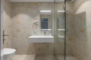 a bathroom with a sink and a glass shower at Roze Boutique Hotel in Liepāja +31 photos