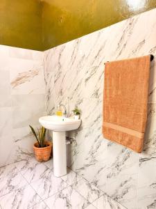 a bathroom with a sink and a towel at Attalah Beach Cottage in Mombasa +27 photos