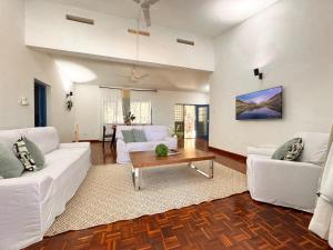 a living room with two white couches and a table at Attalah Beach Cottage in Mombasa